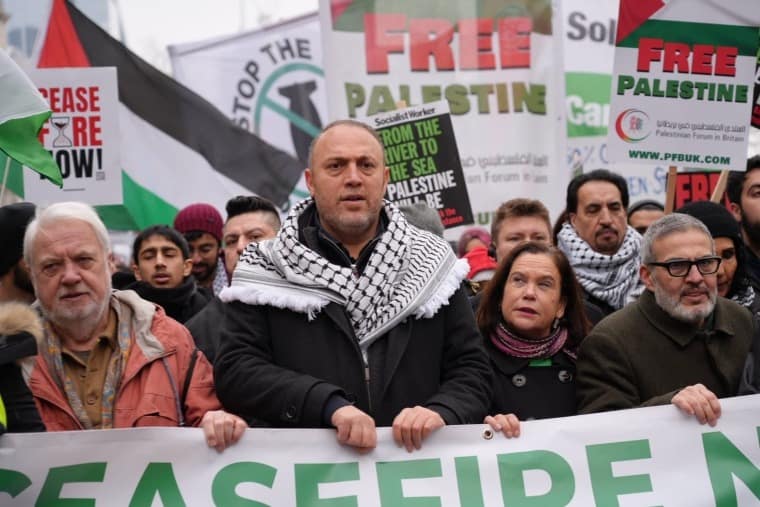 Husam Zomlot marche pour la Palestine à Londres le 13 janvier, il tient une banderole avec d'autres